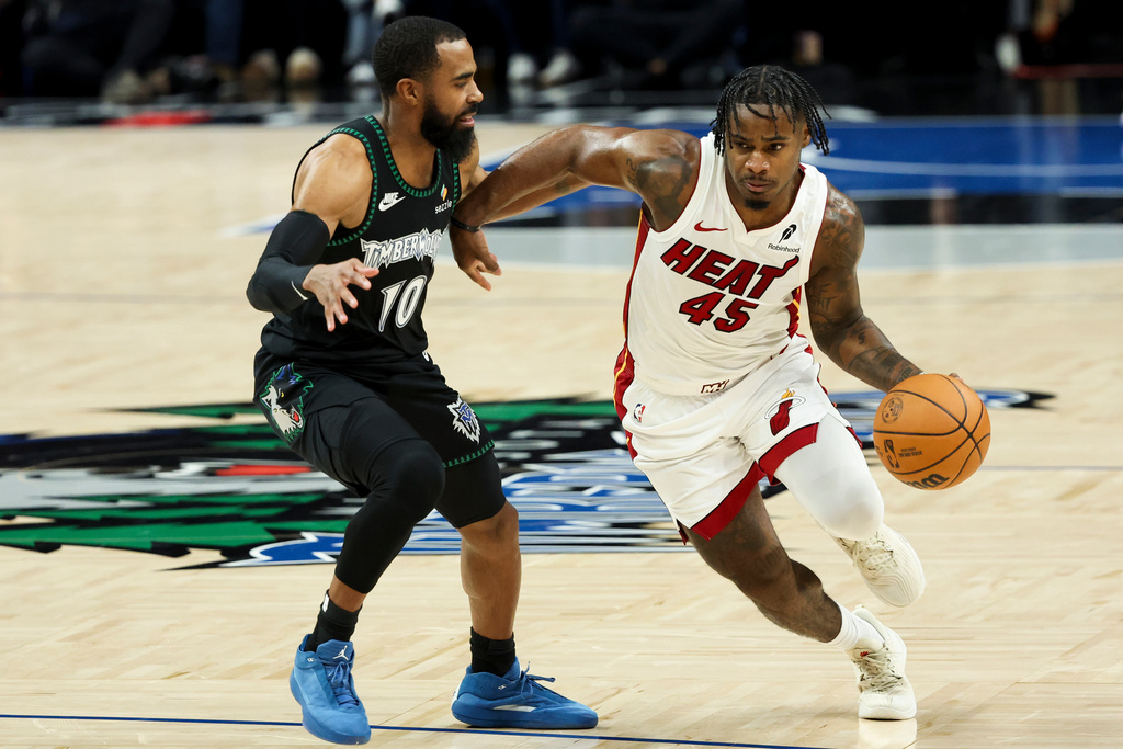 Miami Heat guard Davion Mitchell (45) drives up the court against Minnesota Timberwolves guard Mike Conley (10) during the first half of an NBA basketball game, Tuesday, Jan. 6, 2026, in Minneapolis. (AP Photo/Ellen Schmidt)