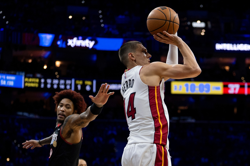 Miami Heat's Tyler Herro, right, shoots the ball as Philadelphia 76ers' Kelly Oubre Jr., left, reaches back during the first half of an NBA basketball game, Thursday, Feb. 26, 2026, in Philadelphia. (AP Photo/Chris Szagola)