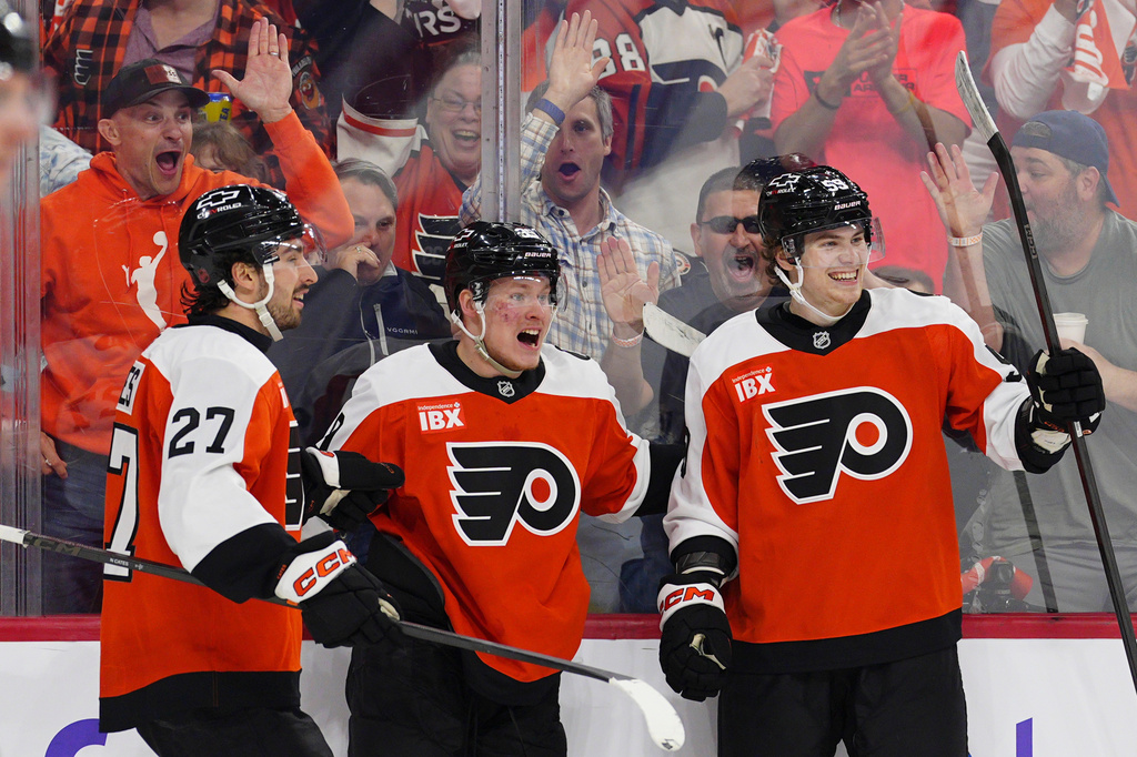 Philadelphia Flyers' Matvei Michkov, center, celebrates his goal with Noah Cates (27) and Oliver Bonk during the second period of an NHL hockey game against the Montréal Canadiens, Tuesday, April 14, 2026, in Philadelphia. (AP Photo/Derik Hamilton)