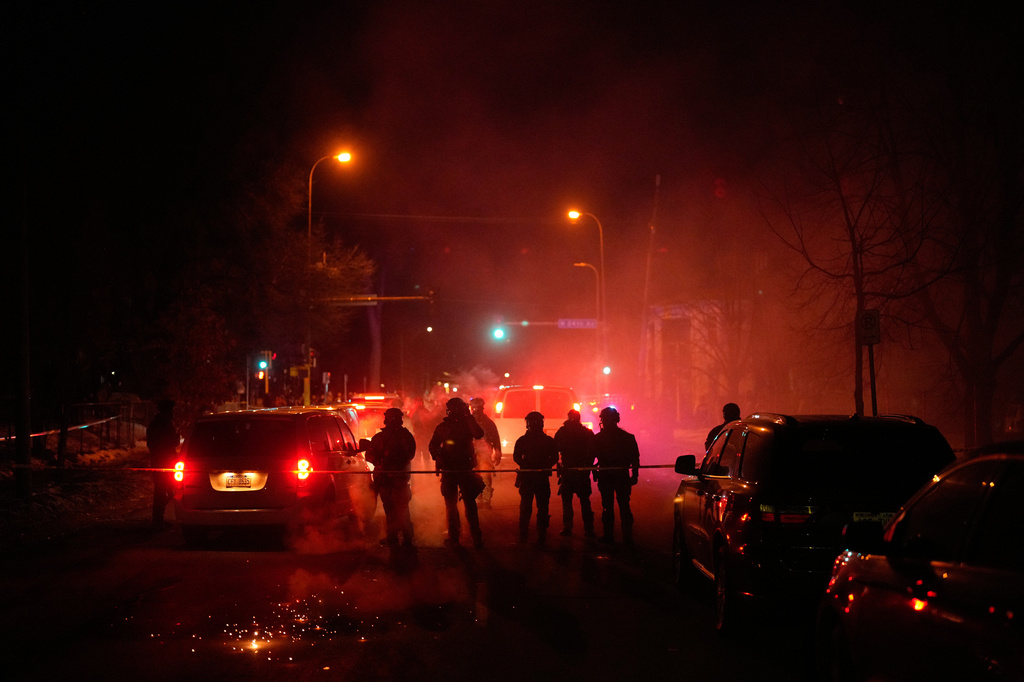 FILE - Tear gas surrounds federal law enforcement officers as they leave a scene after a shooting on Jan. 14, 2026, in Minneapolis. (AP Photo/John Locher, File)