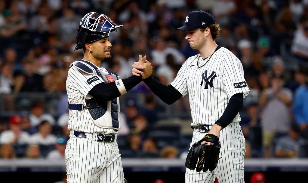New York Yankees' catcher J.C. Escarra and pitcher Cam Schlittler shake hands during the sixth inning of a baseball game against the Cincinnati Reds , Friday, June 19, 2026, in New York. (AP Photo/Noah K. Murray)
