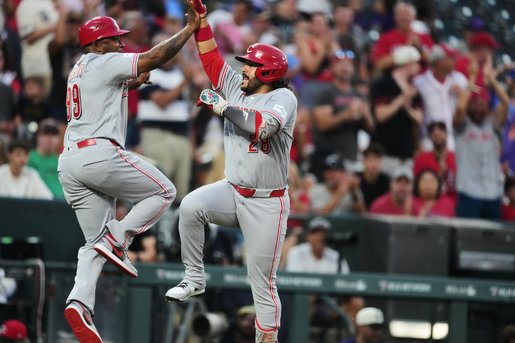 Cincinnati Reds third base coach Willie Harris, left, celebrates with Eugenio Su·rez as he circles the bases after hitting a solo home run off Colorado Rockies relief pitcher Jimmy Herget in the sixth inning of a baseball game Friday, July 17, 2026, in Denver. (AP Photo/David Zalubowski)