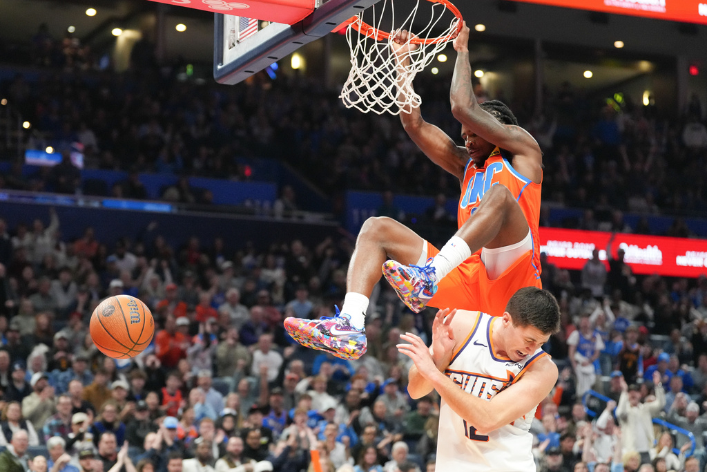 Oklahoma City Thunder guard Cason Wallace, top, dunks over Phoenix Suns Collin Gillespie, bottom, during the second half of an NBA Cup basketball game, Friday, Nov. 28, 2025, in Oklahoma City. (AP Photo/Kyle Phillips)