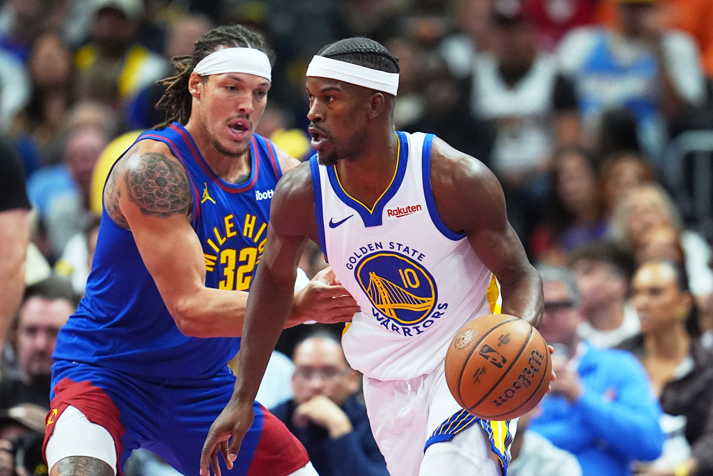 Golden State Warriors forward Jimmy Butler III, right, drives past Denver Nuggets forward Aaron Gordon in the first half of an NBA Cup basketball game Friday, Nov. 7, 2025, in Denver. (AP Photo/David Zalubowski)