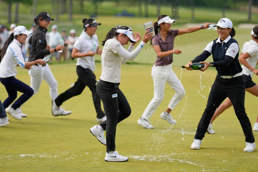Jeeno Thitikul, of Thailand, center, is sprayed with champagne after winning the Mizuho Americas Open golf tournament, Sunday, May 10, 2026, in West Caldwell, N.J. (AP Photo/Seth Wenig)