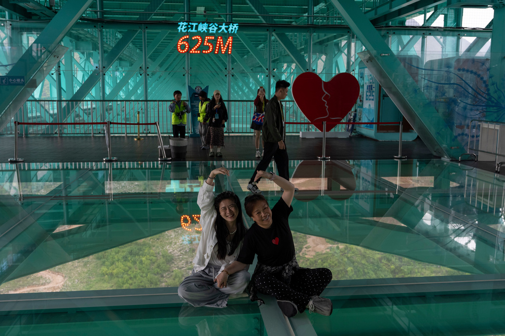 Tourists pose for photos on the Huajiang Grand Canyon Bridge with the sign 625m marking the height of the bridge in Anshun in southwestern China's Guizhou province on Friday, May 29, 2026. (AP Photo/Ng Han Guan)