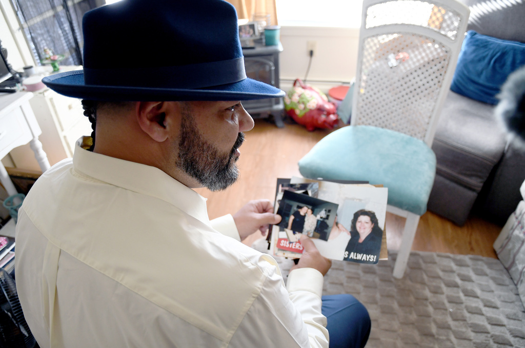 Derrick Johnson, whose mother's body was one of 189 left to decay in the Return to Nature Funeral Home in Penrose, Colo., holds family photos in his aunt's home in Colorado Springs, Colo., on Thursday, Feb. 5, 2026. (AP Photo/Thomas Peipert)