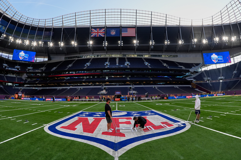 Workers make final preparations to the field before an NFL football game between Indianapolis Colts and Washington Commanders in London, Sunday, Oct. 4, 2026. (AP Photo/David J. Phillip)