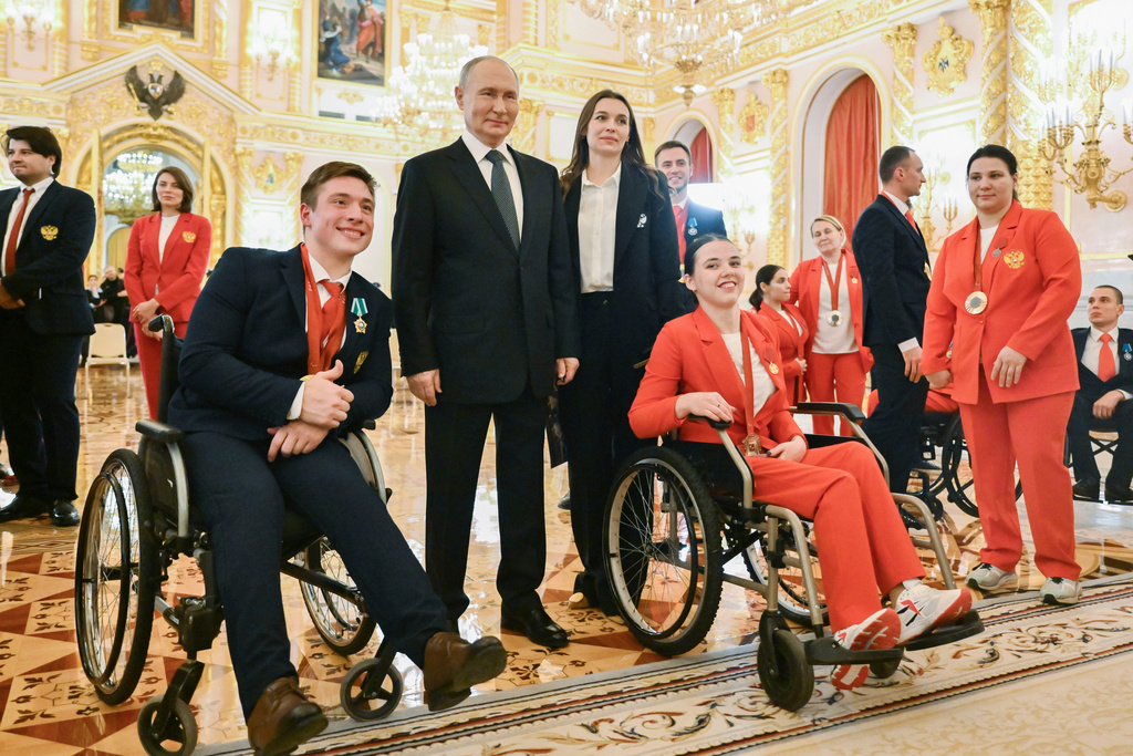FILE - Russian President Vladimir Putin, second left, poses for a photo with Russian Paralympic athletes Aleksei Churkin, front left, who won a silver medal in shot put, and Evgeniia Galaktionova, front right, who won a bronze medal in javelin throw, after an awarding ceremony for the Russian Paralympic Committee's medalists of the Paris 2024 Paralympics in Moscow, Russia, Monday, Dec. 16, 2024. (Kristina Kormilitsyna, Sputnik, Kremlin Pool Photo via AP, File)