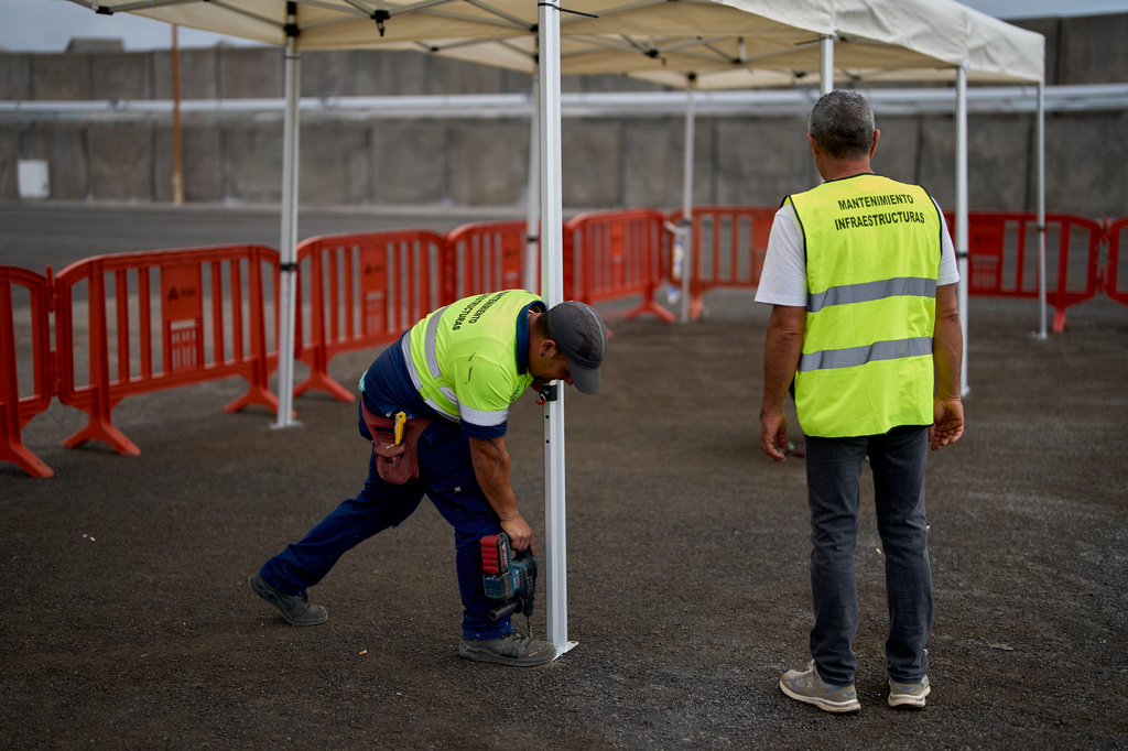 Workers set up temporary shelters in the area where passengers from the MV Hondius cruise ship are expected to arrive at the port of Granadilla in Tenerife, Canary Islands, Spain, Saturday, May 9, 2026. (AP Photo/Manu Fernandez)