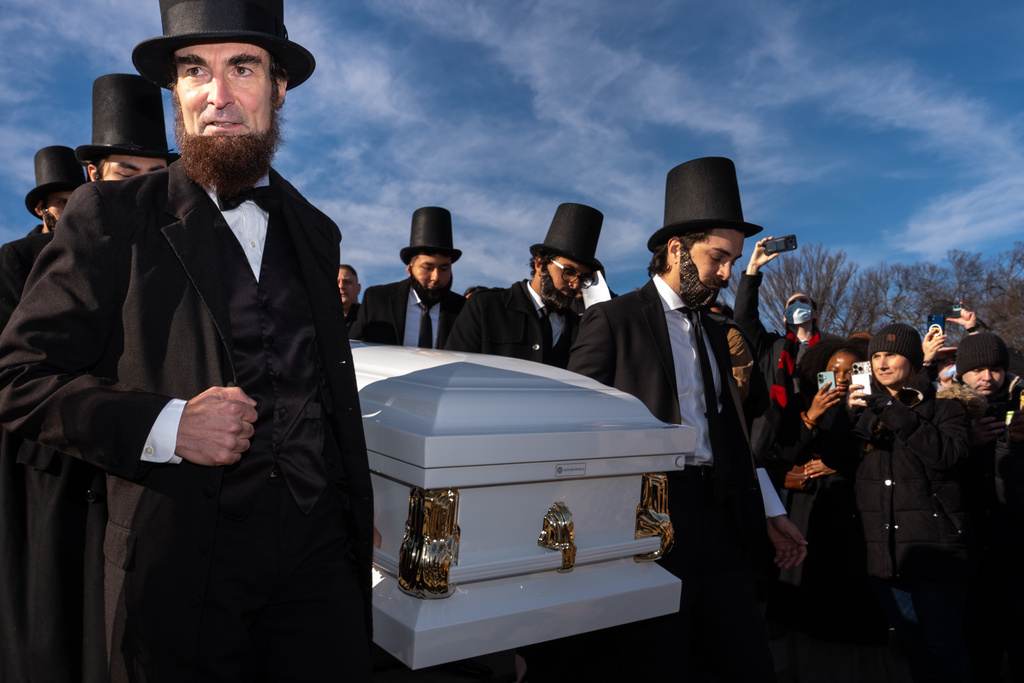 Men dressed as former President Abraham Lincoln carry a casket down the steps in front of the Lincoln Memorial during a mock funeral for the penny, which was discontinued earlier this year, Saturday, Dec. 20, 2025, in Washington. (AP Photo/Julia Demaree Nikhinson)