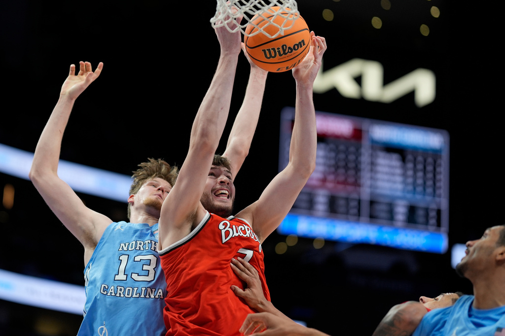 Ohio State center Ivan Njegovan (7) and North Carolina center Henri Veesaar (13) vie for a loose ball during the second half of an NCAA basketball game, Saturday, Dec. 20, 2025, in Atlanta. (AP Photo/Mike Stewart)
