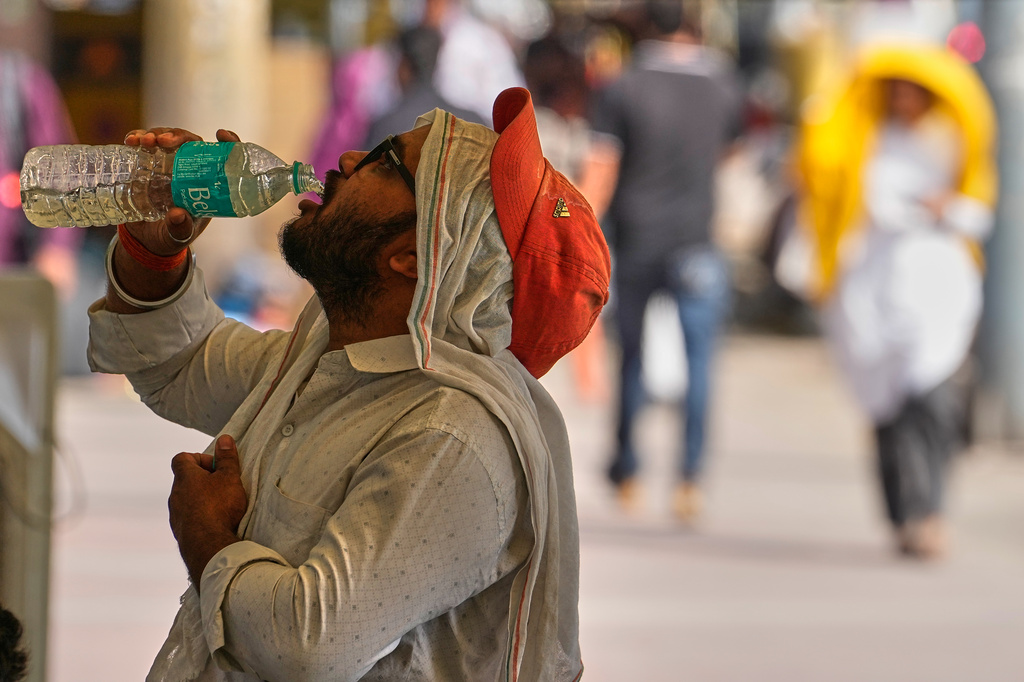 A commuter drinks water on a hot afternoon in New Delhi, India, Wednesday, May 20, 2026. (AP Photo/Manish Swarup)