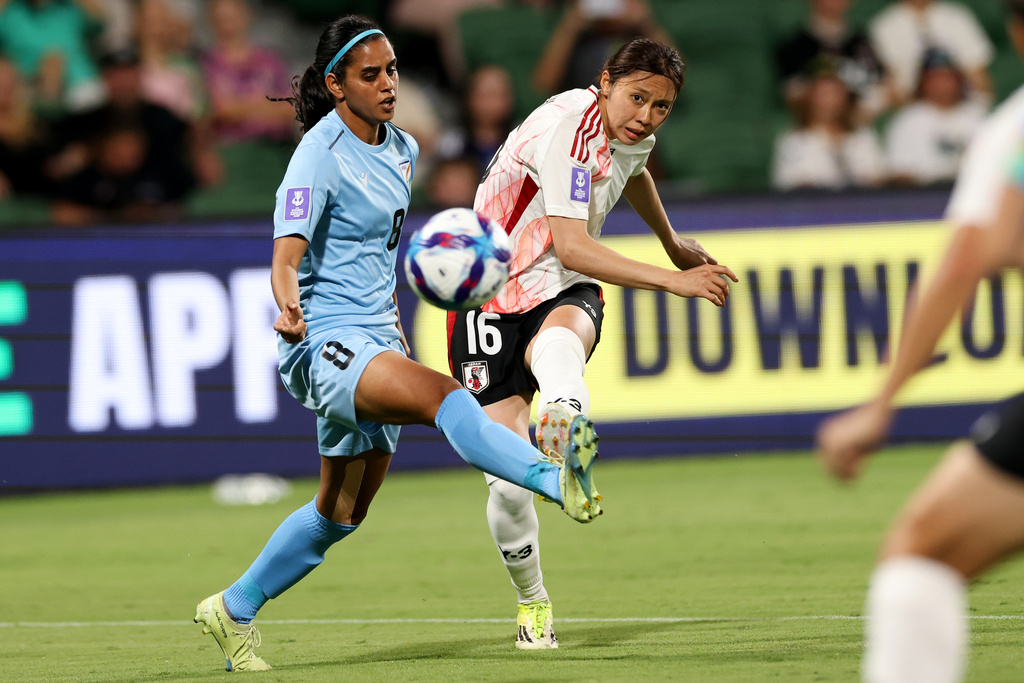 Japan's Yuzuki Yamamoto, right, scores her team's first goal as India's Sanju Yadav attempts to block during the Women's Asian Cup soccer match between Japan and India in Perth, Australia, Saturday, March 7, 2026. (Colin Murty/AAPImage via AP)