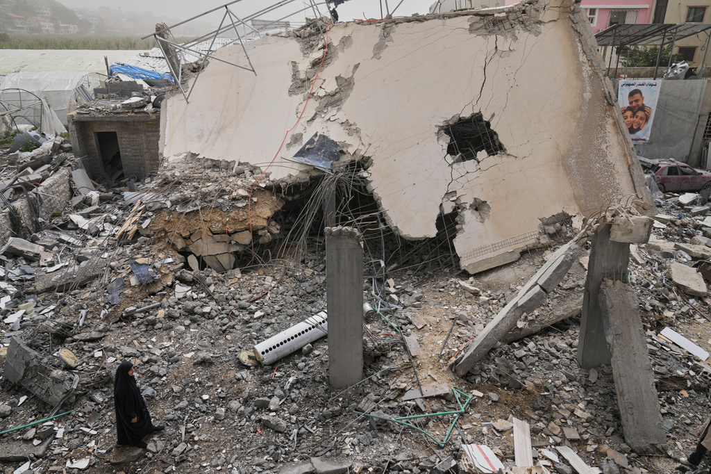 A woman checks a destroyed house that was hit in an Israeli airstrike in Saksakiyeh village, south Lebanon, Friday, April 3, 2026. (AP Photo/Hussein Malla)