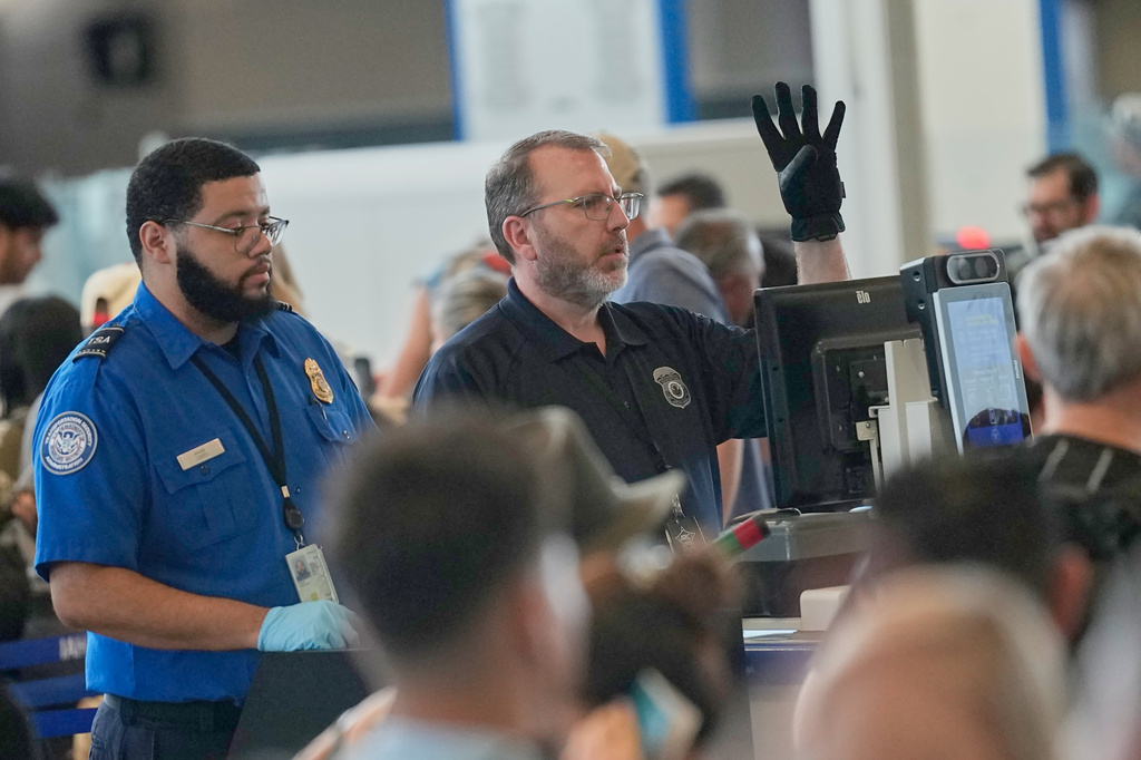 Travelers are screened at a security checkpoint at George Bush Intercontinental Airport Friday, March 27, 2026, in Houston. (AP Photo/David J. Phillip)