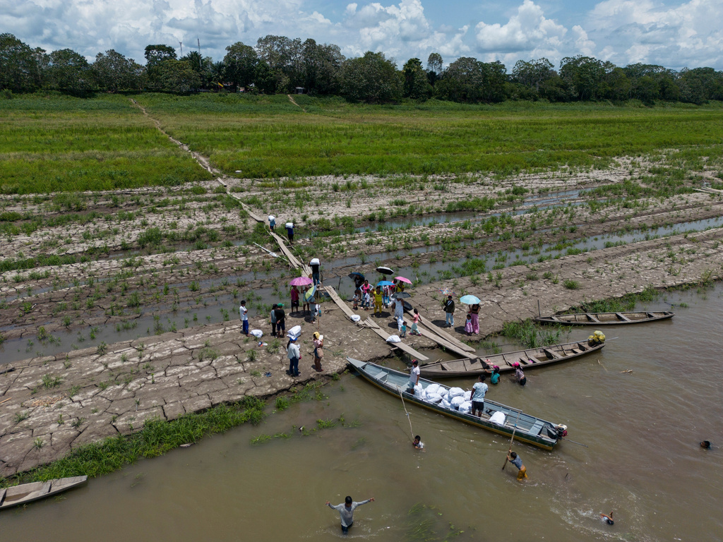 FILE - People from the Tikuna Indigenous receive aid from an NGO because of the drought along the Amazon River in Santa Sofia, on the outskirts of Leticia, Colombia, Oct. 20, 2024. (AP Photo/Ivan Valencia, File)