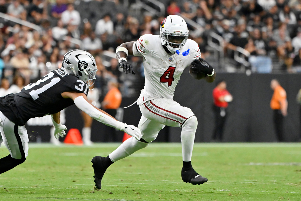 Arizona Cardinals running back Jeremiyah Love (4) runs past Las Vegas Raiders safety Treydan Stukes (31) during the first half of a preseason NFL football game, Thursday, Aug. 13, 2026, in Las Vegas. (AP Photo/David Becker)