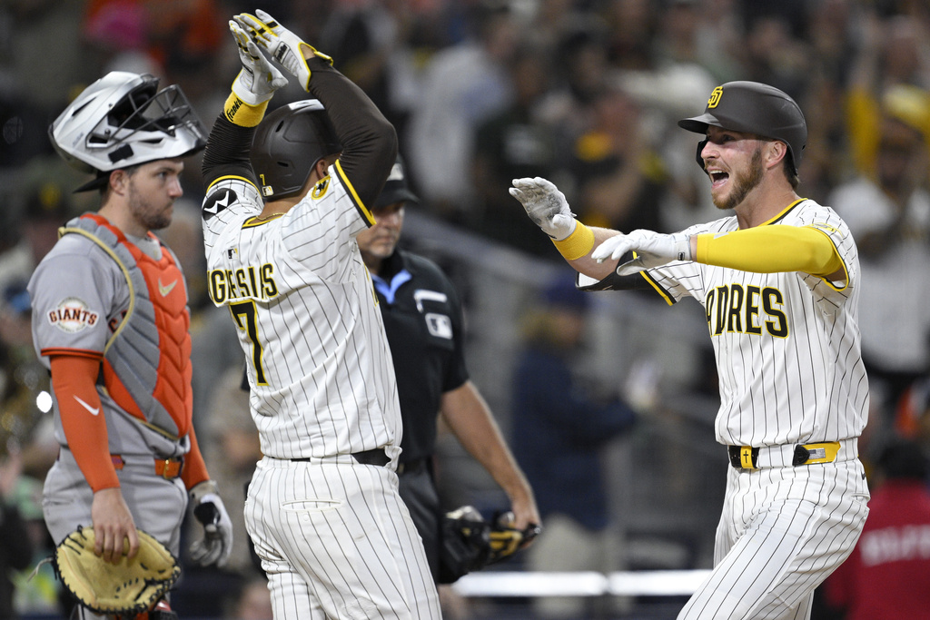 San Diego Padres' Ryan O'Hearn, right, is congratulated by Jose Iglesias (7) after hitting a two-run home run against the San Francisco Giants during the seventh inning of a baseball game Monday, Aug 18, 2025, in San Diego. (AP Photo/Orlando Ramirez)