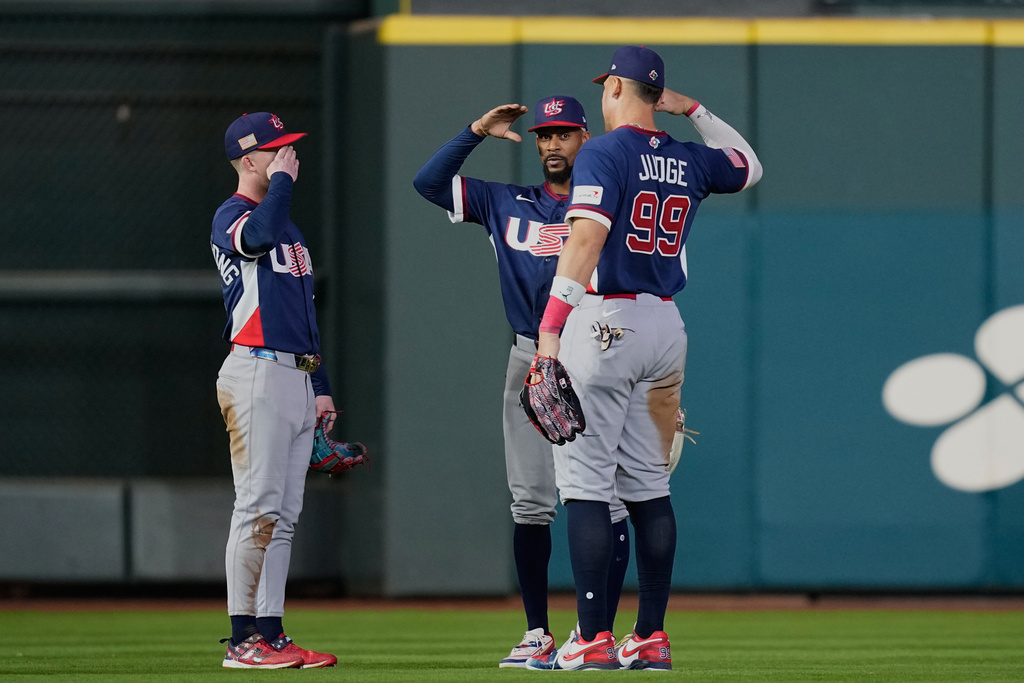United States right fielder Aaron Judge (99) celebrates with teammates Brice Turang, left, and Byron Buxton, center, after their win over Canada in a World Baseball Classic quarterfinal game, Friday, March 13, 2026, in Houston. (AP Photo/David J. Phillip)