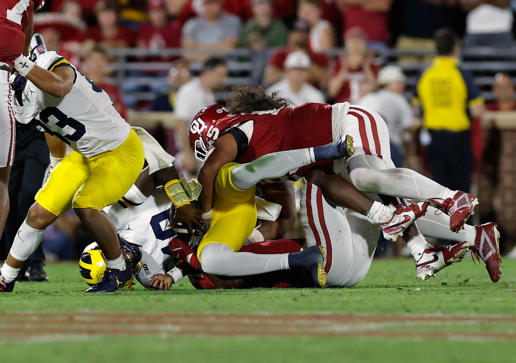 Oklahoma defensive lineman Jayden Jackson (65) sacks Michigan quarterback Bryce Underwood (19) during the second half of an NCAA college football game Saturday, Sept. 6, 2025, in Norman, Okla. (AP Photo/Alonzo Adams)