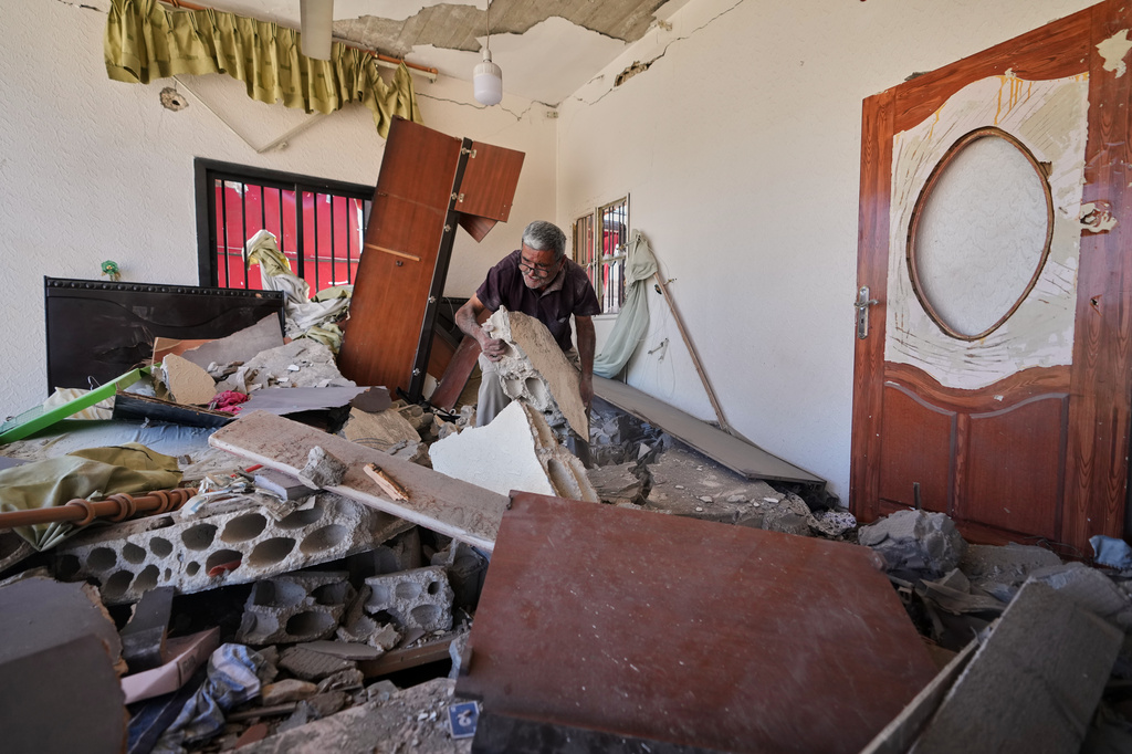 Mohammed Sobeih clears debris inside his home after returning to it following the Israeli military operation in Zawtar al-Gharbieh, Lebanon, Tuesday, July 28, 2026. (AP Photo/Hassan Ammar)