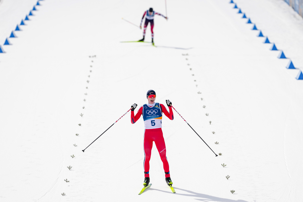 Jens Luraas Oftebro, of Norway, crosses the finish line, ahead of Johannes Lamparter, of Austria, to win the gold medal in the nordic combined individual Gundersen large hill/10km at the 2026 Winter Olympics, in Tesero, Italy, Tuesday, Feb. 17, 2026. (AP Photo/Kirsty Wigglesworth)