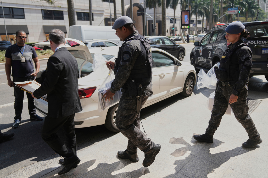 Police officers leave a building with seized documents, during an operation investigating investment funds and the fuel sector, on Avenida Faria Lima, in Sao Paulo, Thursday, Aug. 28, 2025. (AP Photo/Andre Penner)