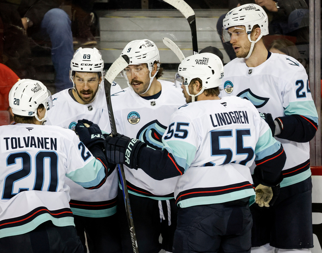 Seattle Kraken's Chandler Stephenson, centre, celebrates his goal with teammates during the second period of an NHL hockey game against the Calgary Flames, in Calgary, Alberta, Thursday, Dec. 18, 2025. (Jeff McIntosh/The Canadian Press via AP)