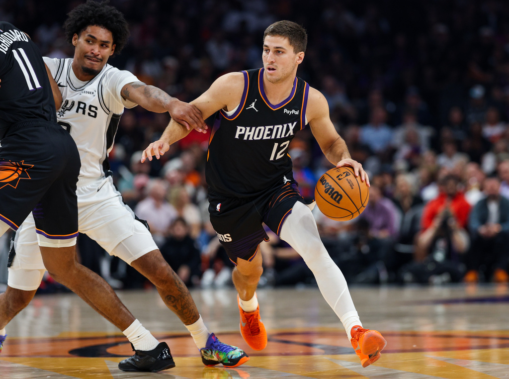 Phoenix Suns guard Collin Gillespie (12) dribbles during the first half of an NBA basketball game against the San Antonio Spurs, Sunday, Nov 2, 2025, in Phoenix. (AP Photo/Mike Christy)