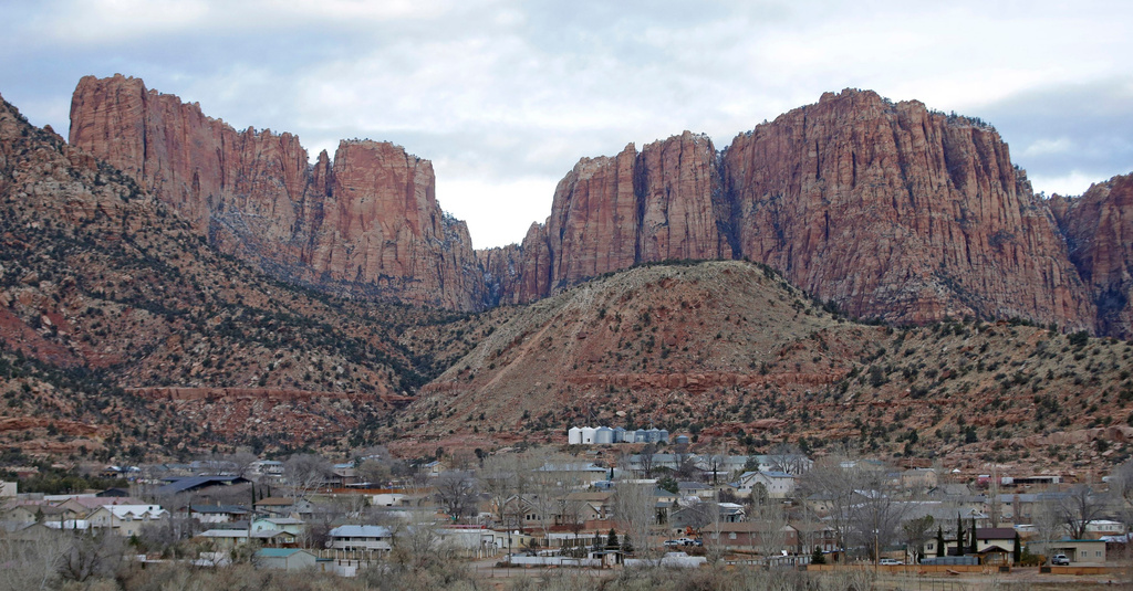 FILE - This photo shows Hildale, Utah, sitting at the base of Red Rock Cliff mountains, with its sister city, Colorado City, Ariz., in the foreground, Dec. 16, 2014. (AP Photo/Rick Bowmer, File)