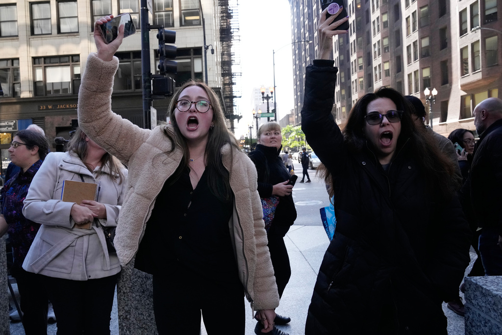 Protesters yell towards U.S. Customs and Border Patrol Gregory Bovino when he leaves federal court in Chicago, Tuesday, Oct. 28, 2025. (AP Photo/Nam Y. Huh)