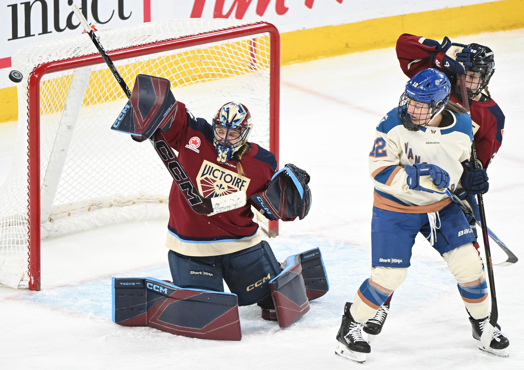 Montreal Victoire goaltender Ann-Renee Desbiens (35) deflects the puck as Victoire's Jessica DiGirolamo (22) defends against Vancouver Goldeneyes' Jenn Gardiner (12) during second period PWHL hockey game in Laval, Que., Wednesday, April 1, 2026. (Graham Hughes/The Canadian Press via AP)