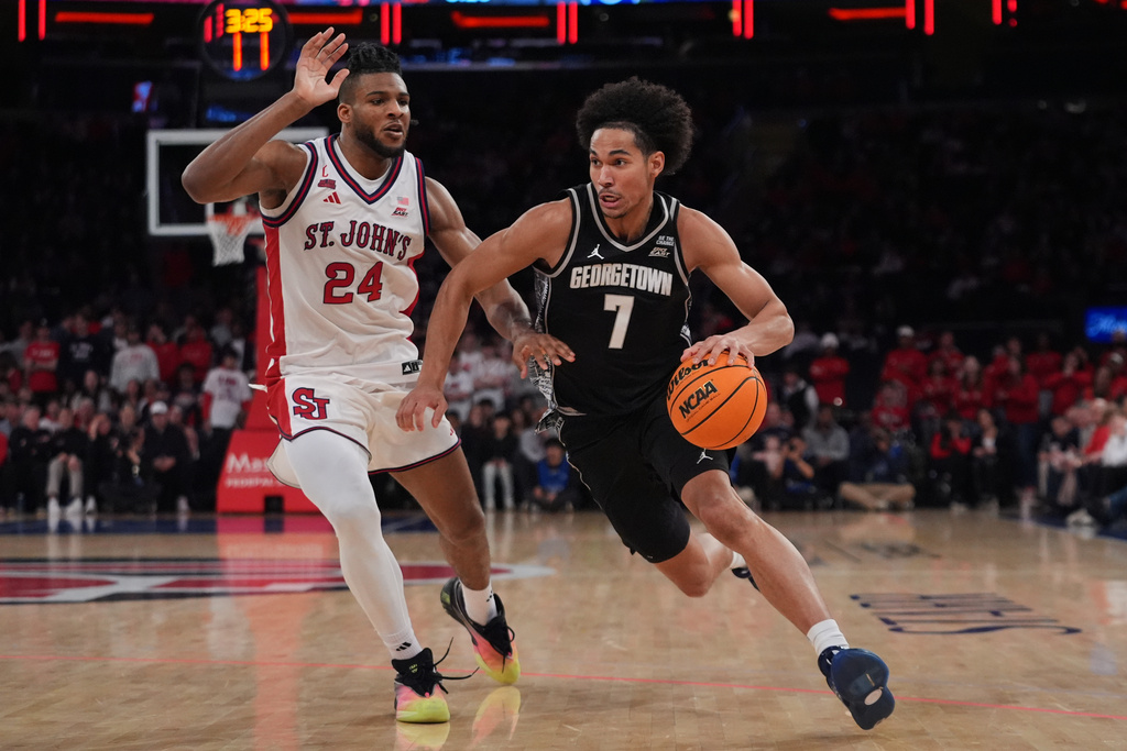 Georgetown Hoyas' Isaiah Abraham (7) drives past St. John's Red Storm's Zuby Ejiofor (24) during the first half of an NCAA college basketball game Tuesday, March 3, 2026, in New York. (AP Photo/Frank Franklin II)