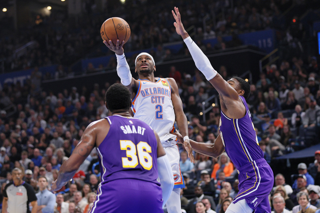 Oklahoma City Thunder guard Shai Gilgeous-Alexander (2) looks to shoot between Los Angeles Lakers guard Marcus Smart (36) and forward Rui Hachimura, right, during the first half of an NBA basketball game Wednesday, Nov. 12, 2025, in Oklahoma City. (AP Photo/Nate Billings)