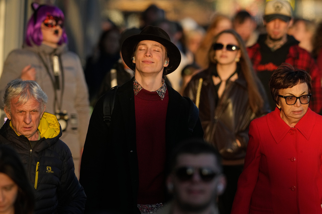 A man walks down the street listening to music on headphones in St. Petersburg, Russia, Friday, April 17, 2026. (AP Photo/Dmitri Lovetsky)