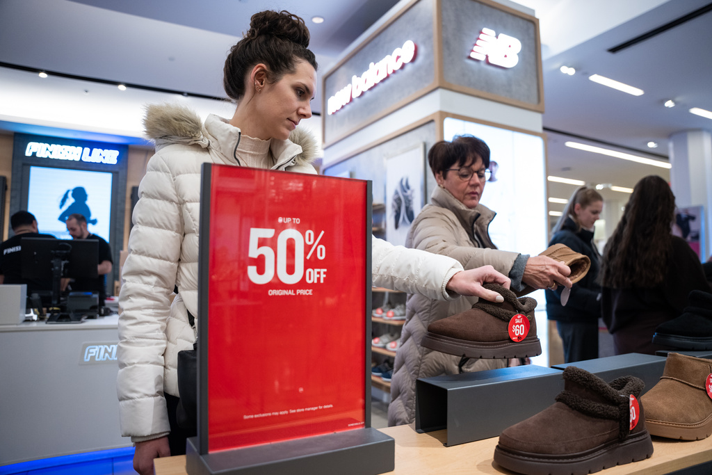 Black Friday shoppers look at shoes at Macy's flagship store in New York on Friday, Nov. 28, 2025. (AP Photo/Angelina Katsanis)