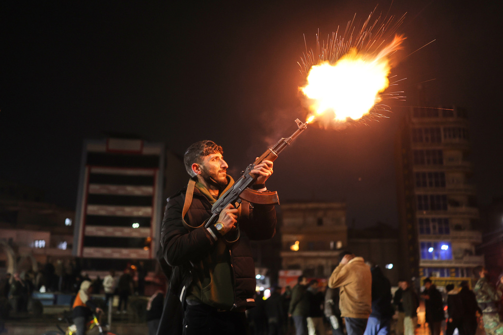 A member of the government forces fires into the air in celebration after taking control of the town from the Syrian Democratic Forces (SDF) in Raqqa, northeastern Syria, Sunday, Jan. 18, 2026. (AP Photo/Ghaith Alsayed)