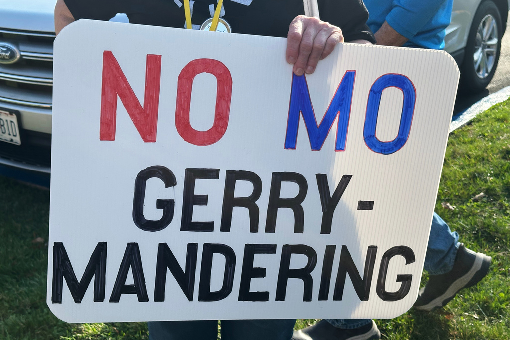 FILE - A person holds a sign opposing the new U.S. House districts passed by the Missouri General Assembly during a protest outside the state Capitol, in Jefferson City, Mo., March 10, 2026. (AP Photo/David A. Lieb, File)
