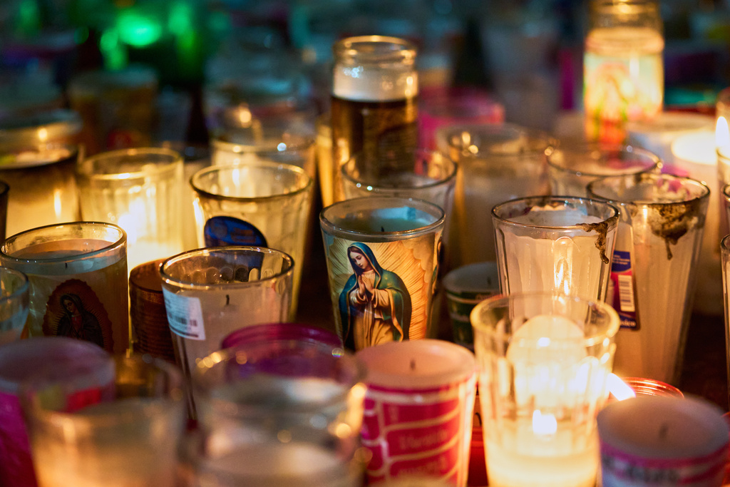 Candles with the image of the Virgin of Guadalupe sit inside the Basilica of Guadalupe in Mexico City, Thursday, Dec. 11, 2025, the day before her feast day. (AP Photo/Claudia Rosel)