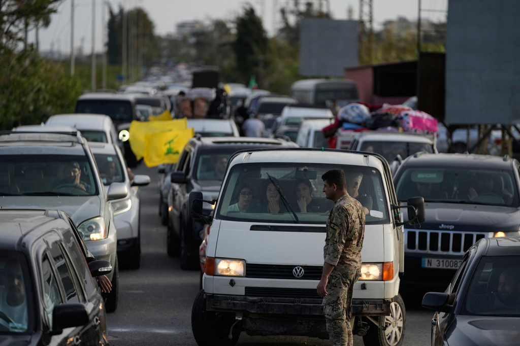 A Lebanese soldier stands as displaced people in cars queue up to cross a destroyed bridge in Qasmiyeh near Tyre city, south Lebanon, as they return to their villages following a ceasefire between Hezbollah and Israel, Friday, April 17, 2026. (AP Photo/Mohammed Zaatari)