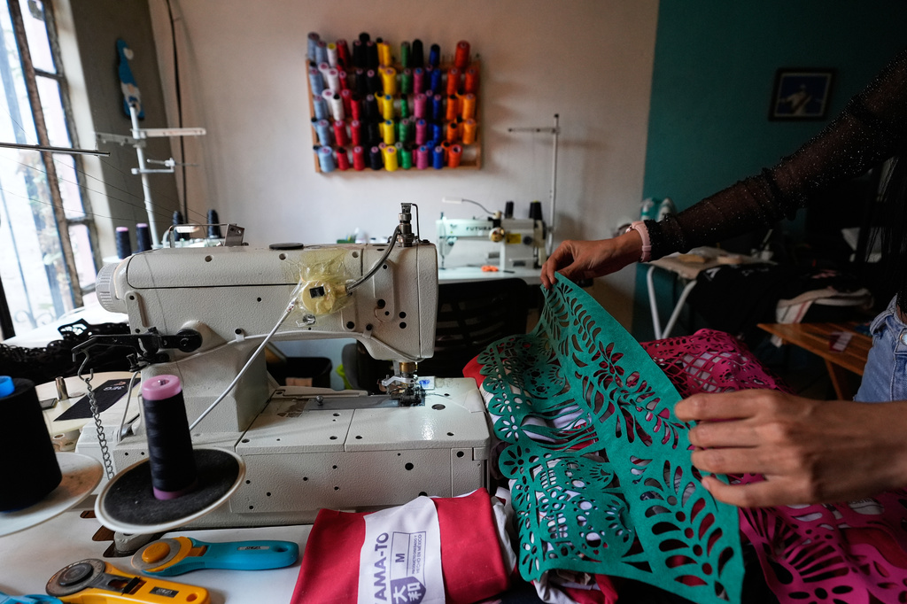 Cande Martinez prepares soccer jerseys, inspired by papel picado and traditional folk art, from the brand Mexclart, in Cuautitlán Izcalli, Mexico, Monday, May 25, 2026. (AP Photo/Marco Ugarte)