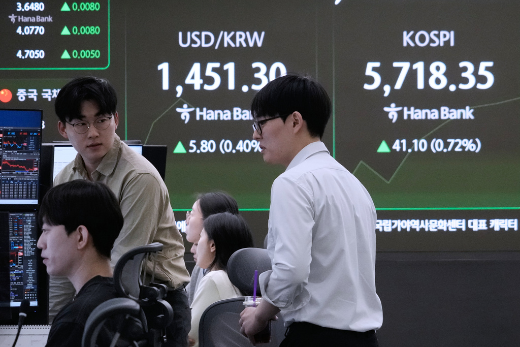 Currency traders work near a screen showing the Korea Composite Stock Price Index (KOSPI), right, and the foreign exchange rate between U.S. dollar and South Korean won at the foreign exchange dealing room of the Hana Bank headquarters in Seoul, South Korea, Friday, Feb. 20, 2026. (AP Photo/Ahn Young-joon)