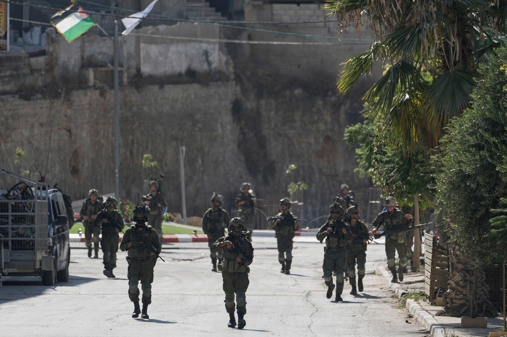 Israeli army soldiers patrol the streets of the occupied West Bank village of Qusra, south of Nablus, Thursday, Aug. 13, 2026. (AP Photo/Majdi Mohammed)
