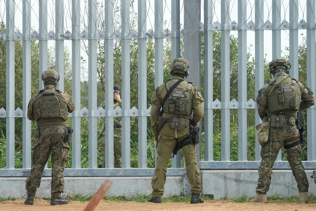 FILE -A Belarusian border guard is seen behind a fence before the visit of Polish Prime Minister Donald Tusk and President of European Commission Ursula von der Leyen on the border between Poland and Belarus, in Krynki, Poland,, Aug. 31, 2025. (AP Photo/Czarek Sokolowski, File)