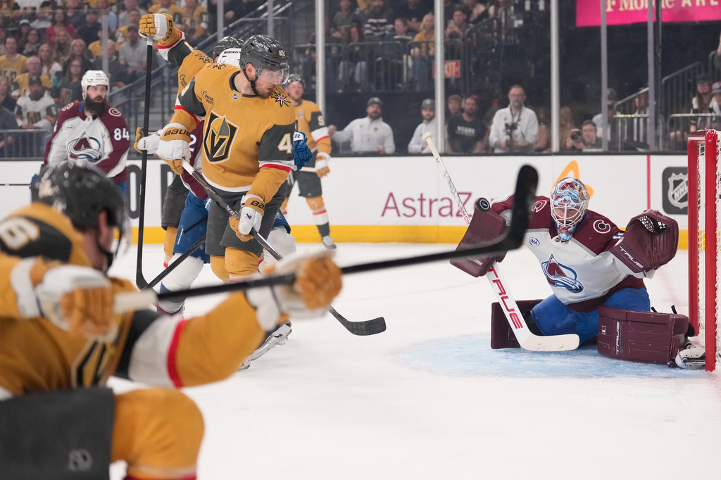 Colorado Avalanche goaltender Scott Wedgewood, right, deflects a shot by Vegas Golden Knights defenseman Kaedan Korczak, left, during the second period in Game 3 of the Western Conference finals NHL hockey Stanley Cup playoff series Sunday, May 24, 2026, in Las Vegas. (AP Photo/Mark J. Terrill)