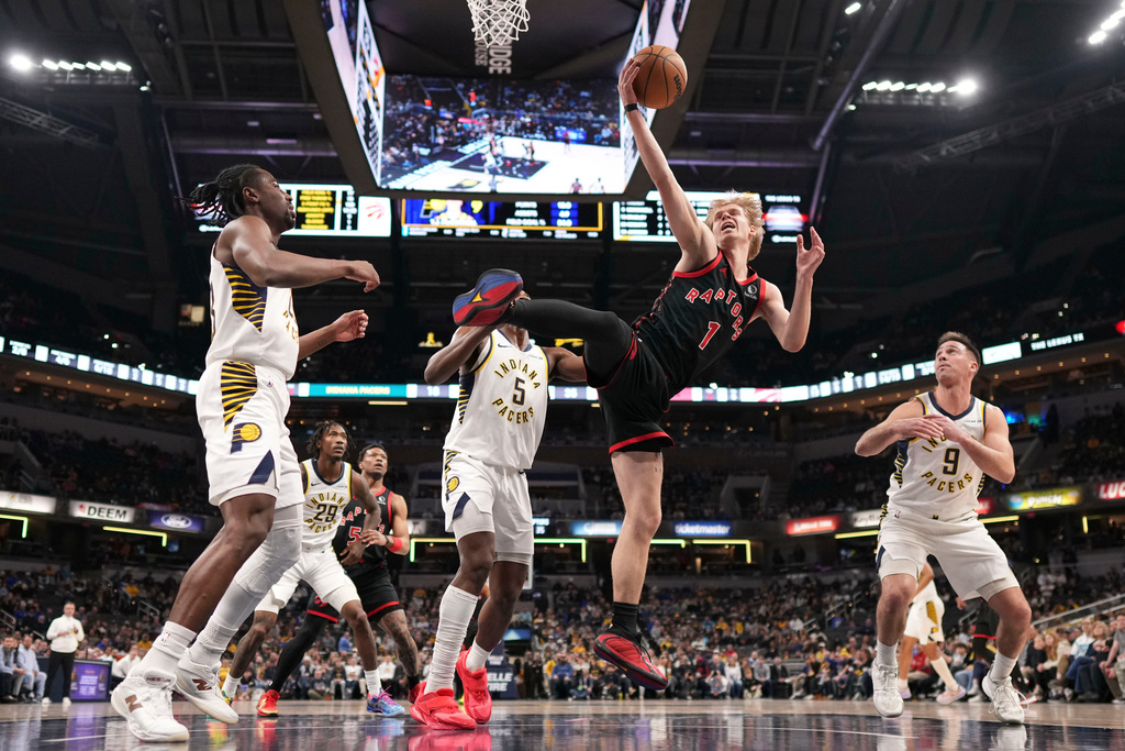 Toronto Raptors guard Gradey Dick (1)pulls down a rebound in front of Indiana Pacers guard T.J. McConnell (9) during the first half of an NBA basketball game in Indianapolis, Wednesday, Jan. 14, 2026. (AP Photo/AJ Mast)