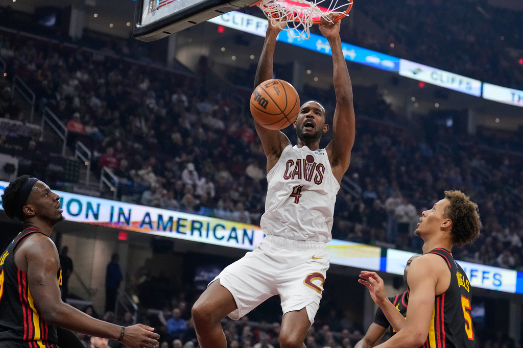 Cleveland Cavaliers center Evan Mobley (4) dunks between Atlanta Hawks forward Onyeka Okongwu, left, and guard Dyson Daniels (5) in the first half of an NBA basketball game in Cleveland, Wednesday, April 8, 2026. (AP Photo/Sue Ogrocki)