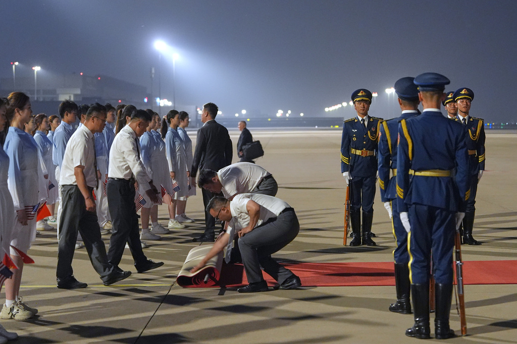 Workers roll out a red carpet as President Donald Trump arrives on Air Force One, Wednesday, May 13, 2026, at Beijing Capital International Airport in Beijing. (AP Photo/Mark Schiefelbein)