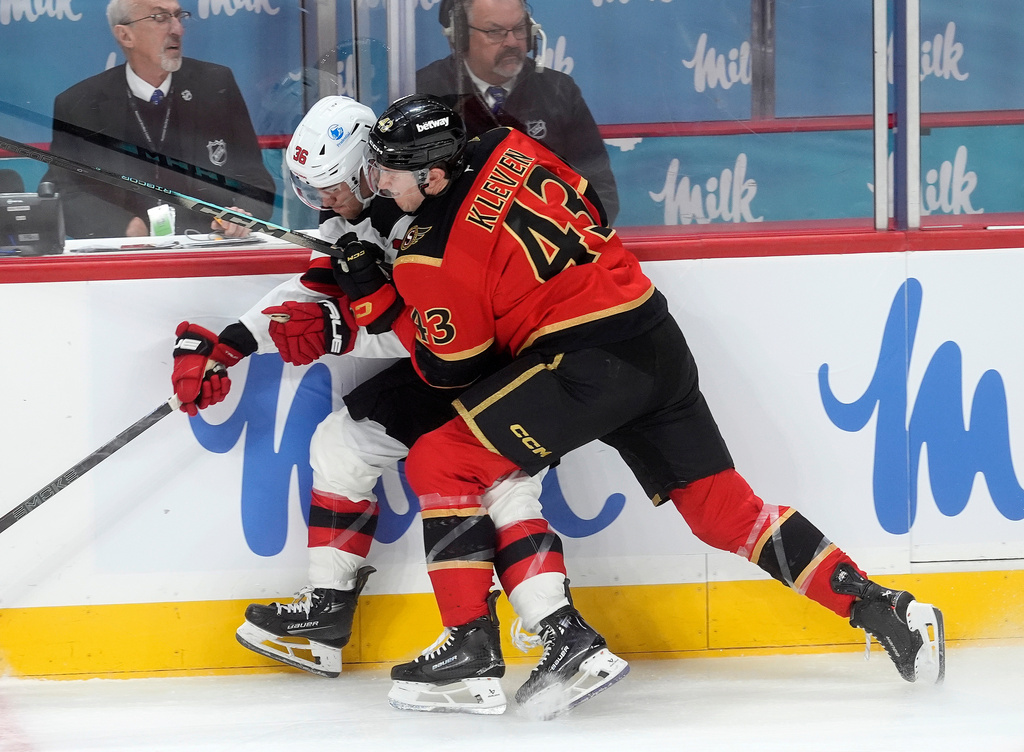 Ottawa Senators defenseman Tyler Kleven (43) checks New Jersey Devils center Angus Crookshank along the boards during the second period of an NHL hockey game, in Ottawa, Ontario, Tuesday, Dec. 9, 2025. (Adrian Wyld/The Canadian Press via AP)